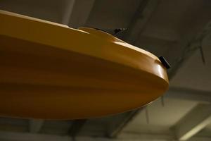 Yellow boat in garage. Boat made of plastic. Canoe storage. Item in stock. photo