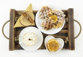 A tasty breakfast with waffles and coffee lying on a wooden tray photo