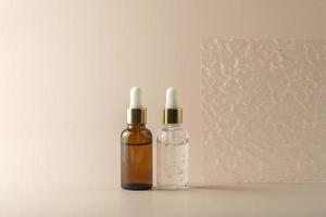 A transparent face serum in dropper bottles or essential oil  or gel standing on a beige background photo