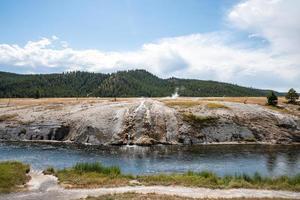 hermosa vista del río firehole en la cuenca del géiser a mitad de camino en el parque de piedra amarilla foto