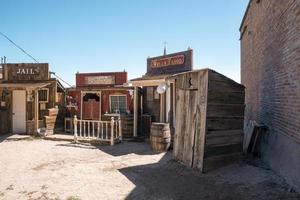 Old shops and jail in historic city by road with clear sky in background photo