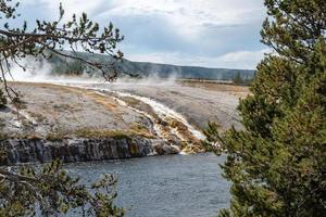 Smoke emitting from hotspring by Firehole River in Midway Geyser Basin at park photo