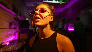 Woman in sunglasses dances in a club party video