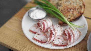 pancetta grön lök och rostat bröd pläterad på en vit maträtt med sås på de sida video