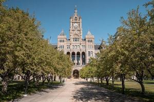 Pasarela en medio de los árboles en la entrada de Salt Lake City y el edificio del condado en verano foto