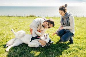 Man and woman playing with dog photo