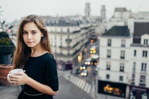 Pretty woman with mug on balcony photo