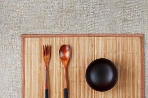 utensilios hechos de madera, tazón y cucharas en una tabla para cortar sobre un fondo blanco foto