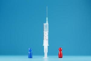 Contradictions of different opinions of a red and blue man about vaccination in a syringe in the center, on a blue background photo