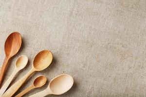 Wooden spoons made of natural wood on burlap fabric as a craft. photo