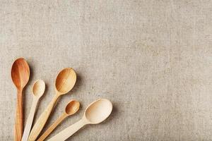 Wooden spoons made of natural wood on burlap fabric as a craft. photo