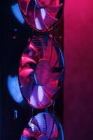 Large and powerful graphics card with three fans with blue pink light. photo