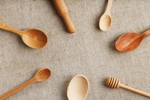 Natural wood spoons in a row on burlap fabric. Natural natural materials. photo