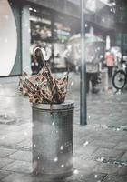 Broken umbrella in trash bin in snowy day photo