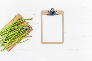 Fresh green asparagus with paper clipboard mockup photo