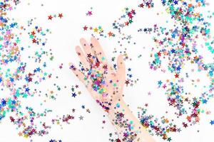 Woman hand with festive color star confetti photo