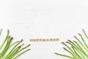 Fresh green asparagus on white wooden background photo