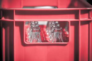 Red Plastic Crate with Empty Glass Bottles photo