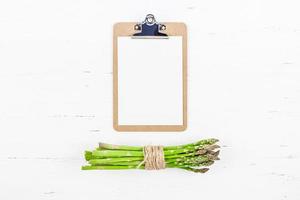 Fresh green asparagus with paper clipboard mockup photo