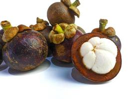 Mangosteen and cross section showing the thick purple skin and white flesh of the queen of friuts, on white background photo