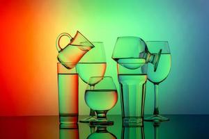 algunos vasos para diferentes bebidas apilados en un fondo colorido foto