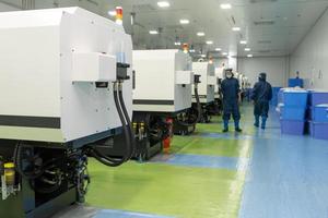 The workers in the workshop with molding machine for the production of medical production photo