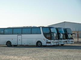 los autobuses de un turno de pasajeros se paran en una fila en un sitio de construcción foto