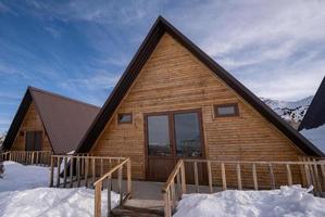 The close-up wooden cottages surrounded by snow. A recreation area in the mountains photo