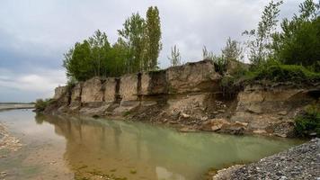 A muddy river with green vegetation on the shore photo