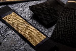 A closeup shot of strips of patterned black and gold fabric for fashion design photo