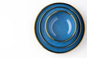 A set of blue ceramic plates on a white background. Top view photo