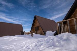 The wooden cottages surrounded by snow. A recreation area in the mountains photo