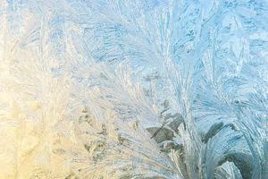 ventana de invierno congelada con textura de patrón de escarcha de hielo brillante. símbolo de maravilla de navidad, fondo abstracto. baja temperatura del extremo norte, nieve de hielo natural sobre vidrio escarchado, clima frío de invierno al aire libre. foto