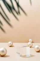 A minimalistic scene of glass podium with christmas pine tree and balls on beige background photo