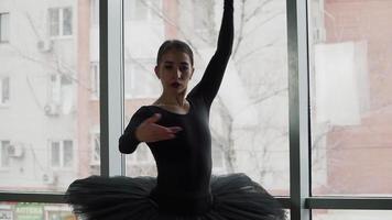 ballerina on a background of the city a beautifully moving dance. In a black tutu and Pointe shoes. The image of the black Swan from the ballet. Slow motion video