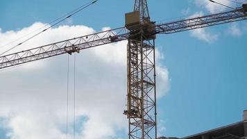 Big industrial construction crane with beautiful cloudy sky background. City development video