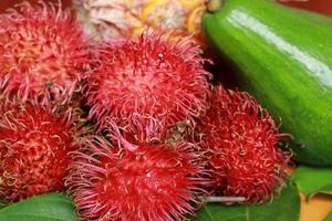 Rambutan fruit on wooden table. Tropical fruit for beverages and drinks photo