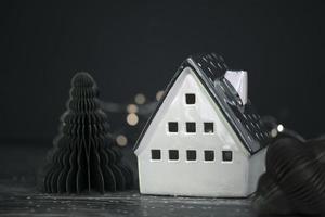 Stylish ceramic decorative Christmas house on a dark background. photo