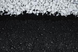 asfalto nuevo sobre grava blanca. vista de arriba hacia abajo fondo plano de asfalto recién puesto. foto