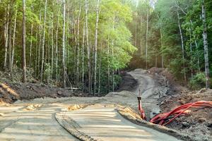 Laying a new winding road through a forest ravine. photo