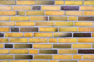 Detailed view at a colorful old and weathered brick wall texture as a panoramic background. photo