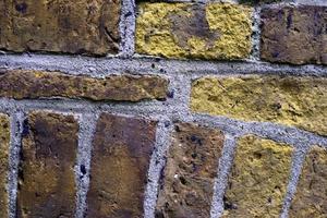 Detailed view at a colorful old and weathered brick wall texture as a panoramic background. photo