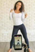 Latin woman created her dancing video by smartphone camera. To share video to social media application. photo