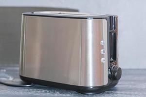 modern electric metallictoaster on grey wooden table in kitchen. electrical appliances for cooking photo