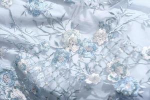 beautiful blue color lace fabric with sequins and embroidery. textile for party dress or prom dress. wedding outfit sewing. photo