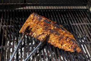 Meat being grilled on a grill outdoors photo