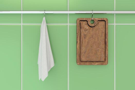 una tabla de cortar y una toalla colgadas en un estante para ollas de cocina junto a la pared de azulejos. foto