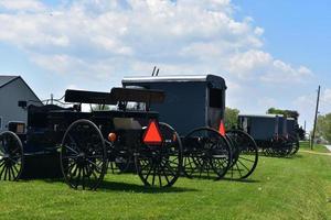 carros y buggies amish estacionados en una granja foto