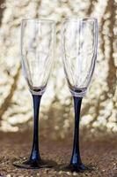 Glasses made of glass with black legs on a shiny background. Glitter background photo