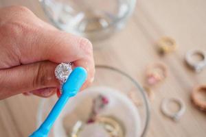 Jeweller hand cleaning and polishing vintage jewelry diamond ring closeup photo